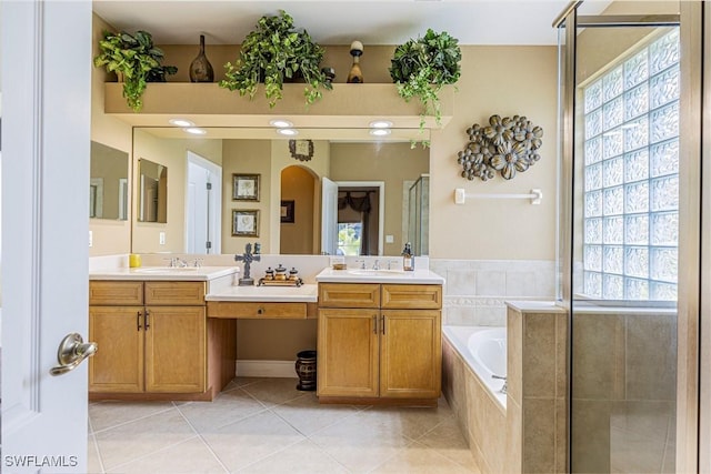 full bathroom with a shower stall, tile patterned floors, a bath, and a sink