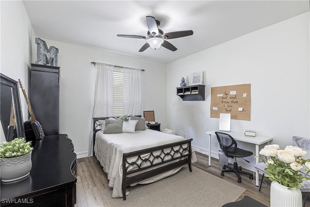 bedroom featuring baseboards, wood finished floors, and a ceiling fan