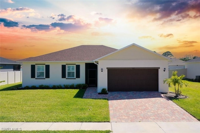 6667 Estero Bay Dr, Fort Myers, FL 33908 - ranch-style home featuring stucco siding, fence, an attached garage, decorative driveway, and a yard