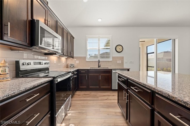 6667 Estero Bay Dr, Fort Myers, FL 33908 - kitchen with a wealth of natural light, light stone counters, a sink, and stainless steel appliances