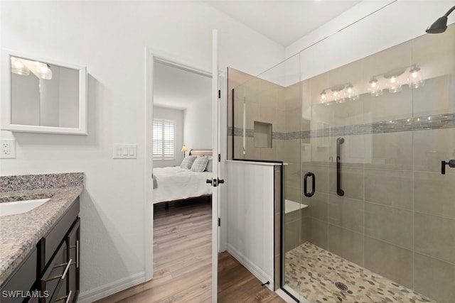 6667 Estero Bay Dr, Fort Myers, FL 33908 - ensuite bathroom with connected bathroom, vanity, a shower stall, wood finished floors, and baseboards