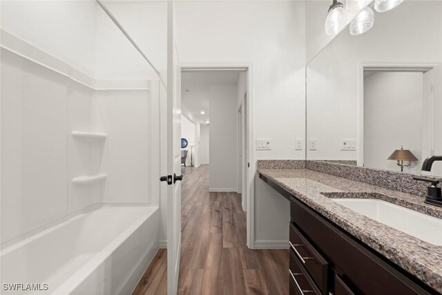 6667 Estero Bay Dr, Fort Myers, FL 33908 - full bathroom with baseboards, tub / shower combination, wood finished floors, and vanity