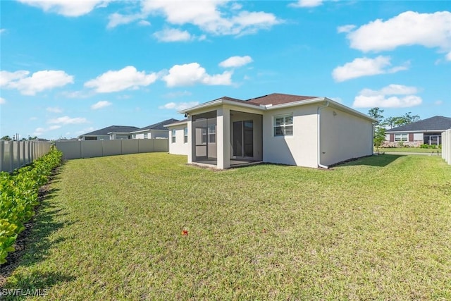 6667 Estero Bay Dr, Fort Myers, FL 33908 - back of house with stucco siding, a sunroom, a fenced backyard, and a yard
