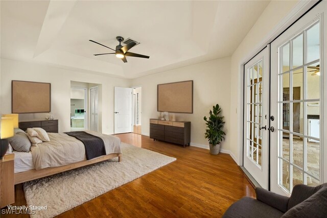 920 SW 4th Pl, Cape Coral, FL 33991 - bedroom with access to exterior, baseboards, a tray ceiling, french doors, and wood finished floors