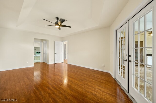 920 SW 4th Pl, Cape Coral, FL 33991 - spare room featuring french doors, a raised ceiling, ceiling fan, and wood finished floors