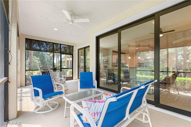 sunroom featuring a ceiling fan and plenty of natural light
