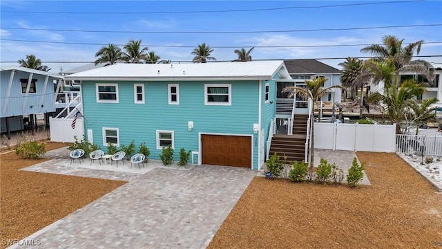 360 Bayland Rd, Fort Myers Beach, FL 33931 - back of property with driveway, a patio area, stairway, fence, and a garage