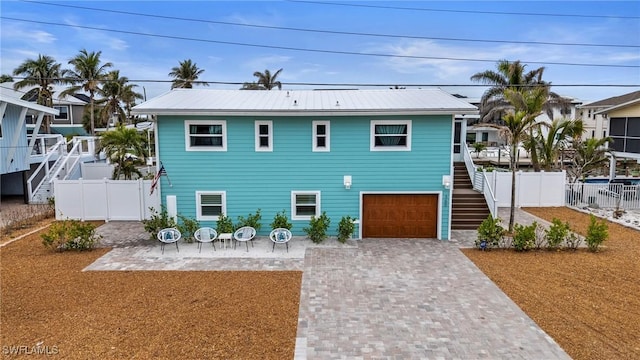 360 Bayland Rd, Fort Myers Beach, FL 33931 - view of front facade featuring metal roof, fence, decorative driveway, a garage, and stairway