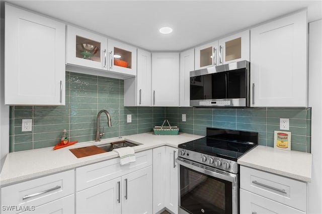 360 Bayland Rd, Fort Myers Beach, FL 33931 - kitchen featuring white cabinets, a sink, stainless steel appliances, and decorative backsplash
