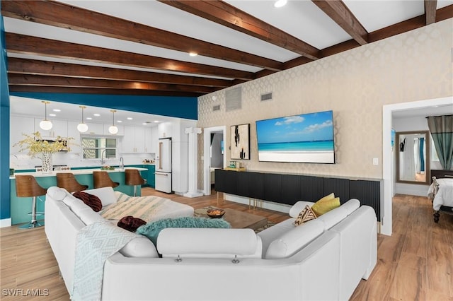 360 Bayland Rd, Fort Myers Beach, FL 33931 - living room featuring baseboards, wallpapered walls, beamed ceiling, and light wood finished floors
