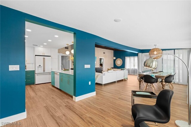 360 Bayland Rd, Fort Myers Beach, FL 33931 - kitchen with light countertops, white cabinets, light wood-type flooring, and white appliances