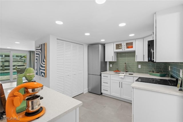 360 Bayland Rd, Fort Myers Beach, FL 33931 - kitchen featuring light countertops, decorative backsplash, a sink, freestanding refrigerator, and white cabinets