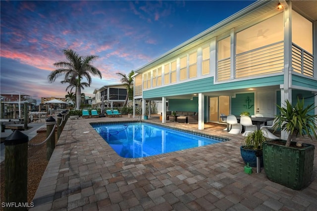 360 Bayland Rd, Fort Myers Beach, FL 33931 - pool at dusk featuring a fenced in pool, an outdoor living space, and a patio