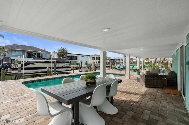 360 Bayland Rd, Fort Myers Beach, FL 33931 - view of patio / terrace featuring an outdoor pool, boat lift, a residential view, outdoor dining space, and a boat dock