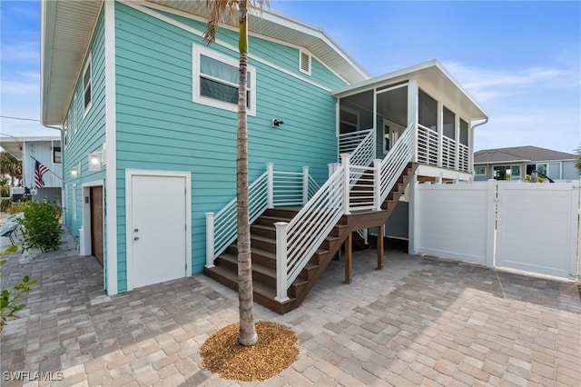 360 Bayland Rd, Fort Myers Beach, FL 33931 - back of property featuring a sunroom, fence, a gate, and stairway