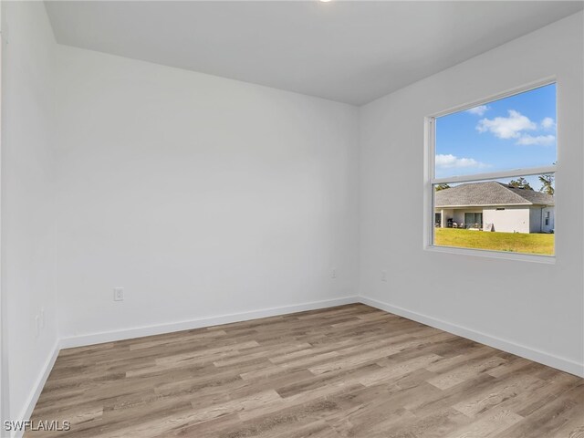1025/1027 Meadow Rd, Lehigh Acres, FL 33973 - spare room with baseboards and wood finished floors