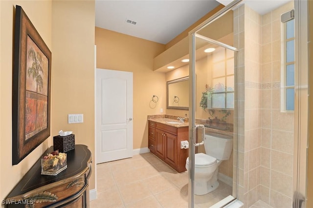 bathroom with toilet, a shower stall, tile patterned flooring, baseboards, and vanity