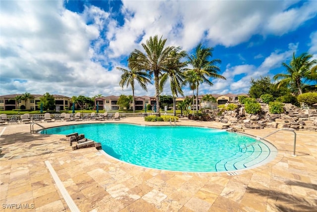 pool featuring a patio area and a residential view