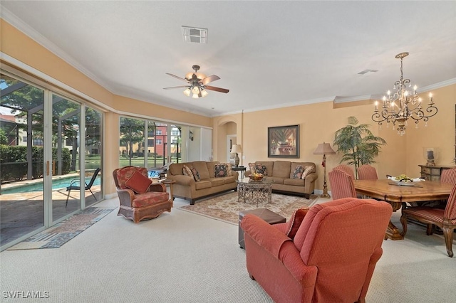 carpeted living area featuring arched walkways, visible vents, ceiling fan with notable chandelier, and ornamental molding