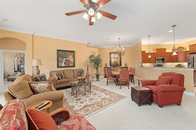 living room with crown molding, ceiling fan with notable chandelier, arched walkways, and light carpet
