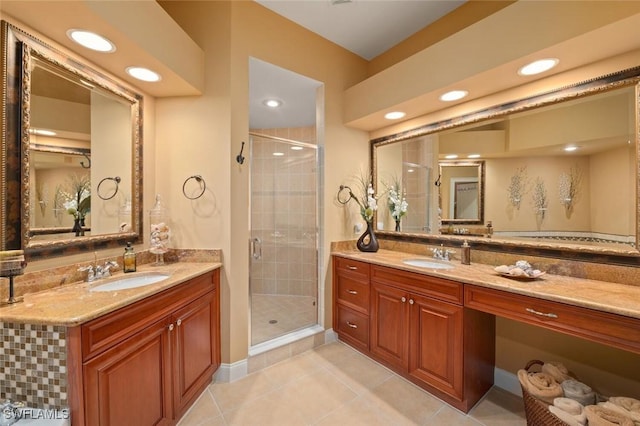 bathroom featuring a stall shower, two vanities, and a sink