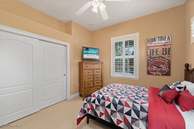 carpeted bedroom featuring baseboards, a closet, and ceiling fan