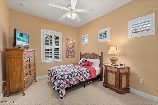 bedroom featuring light carpet, ceiling fan, and baseboards