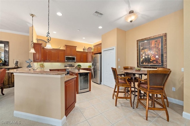 kitchen with visible vents, brown cabinets, appliances with stainless steel finishes, a peninsula, and hanging light fixtures