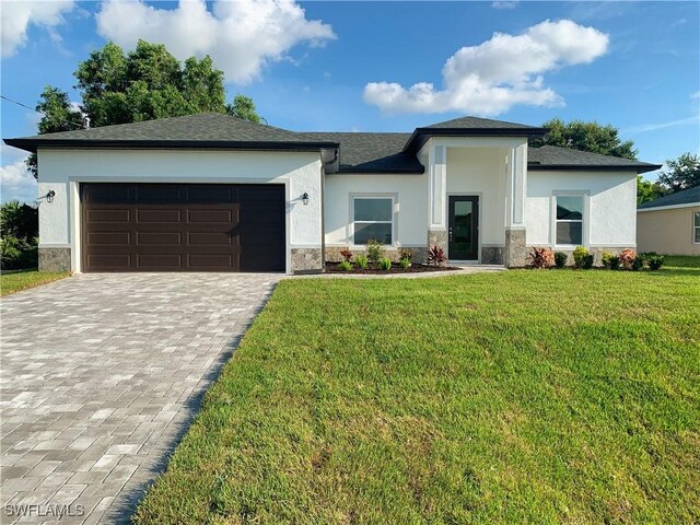 202 NE 25th St, Cape Coral, FL 33909 - prairie-style home with stucco siding, a front lawn, decorative driveway, and a garage
