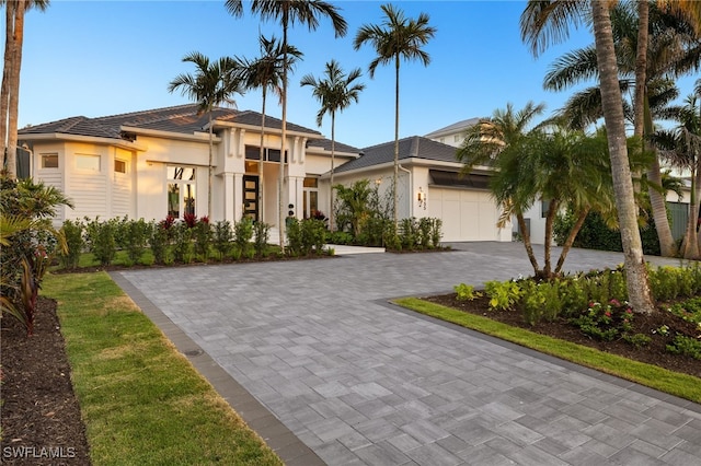 1955 Tarpon Rd, Naples, FL 34102 - view of front of house featuring stucco siding, an attached garage, decorative driveway, and a tiled roof