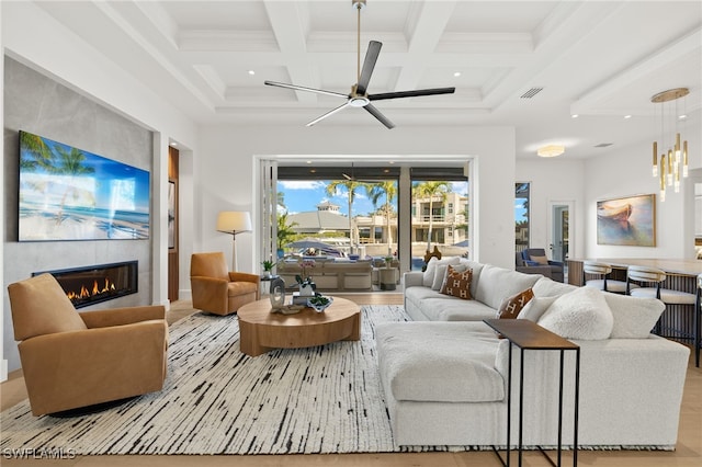 living area featuring a tile fireplace, visible vents, beam ceiling, and coffered ceiling