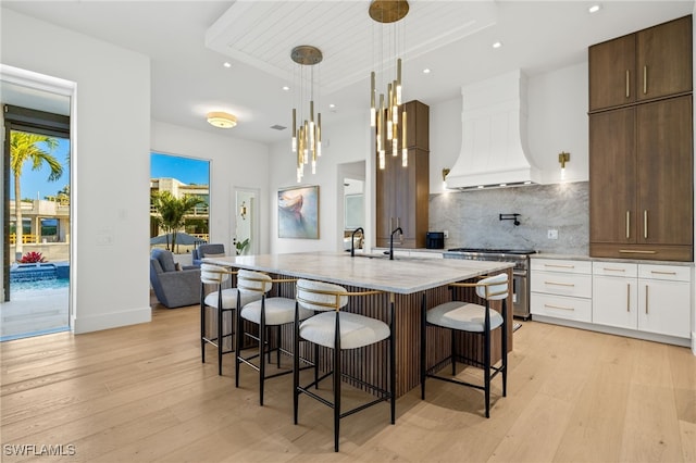 1955 Tarpon Rd, Naples, FL 34102 - kitchen featuring high end stove, premium range hood, light wood-style floors, recessed lighting, and modern cabinets