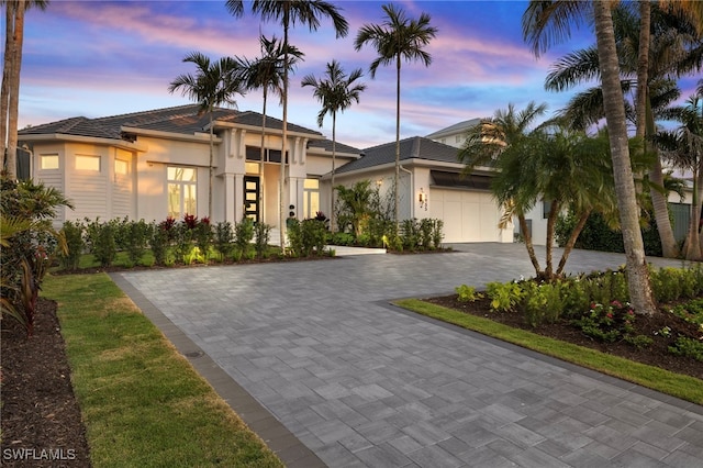1955 Tarpon Rd, Naples, FL 34102 - view of front of property featuring an attached garage, stucco siding, decorative driveway, and a tiled roof