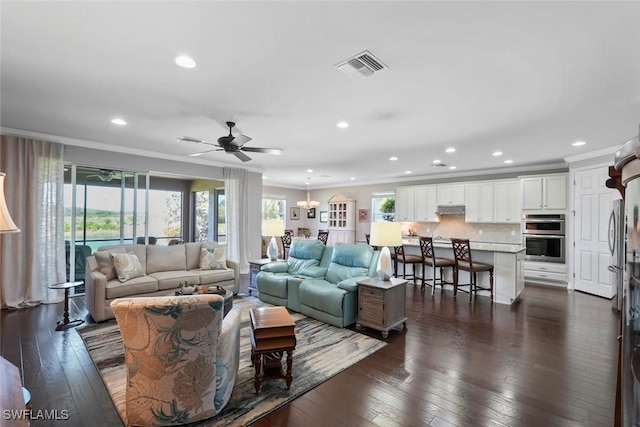 living area with visible vents, a wealth of natural light, and crown molding