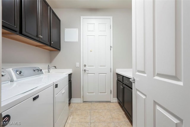 laundry room featuring light tile patterned floors, a sink, baseboards, separate washer and dryer, and cabinet space