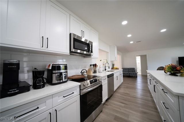 2333 Westwood Rd, North Fort Myers, FL 33917 - kitchen with stainless steel appliances, a sink, tasteful backsplash, white cabinetry, and recessed lighting