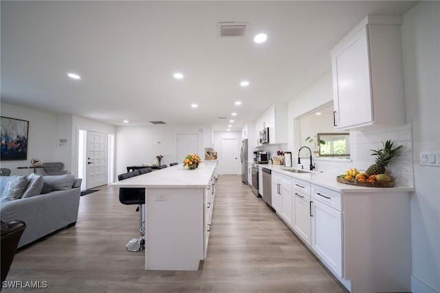 2333 Westwood Rd, North Fort Myers, FL 33917 - kitchen featuring open floor plan, a breakfast bar, appliances with stainless steel finishes, a sink, and white cabinetry