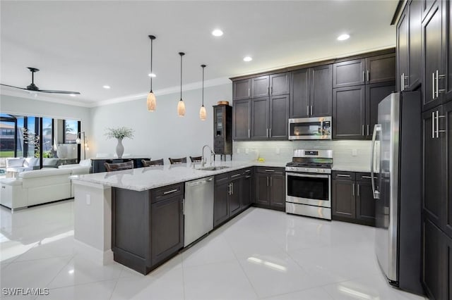 4318 Aurora St, Naples, FL 34119 - kitchen featuring stainless steel appliances, a peninsula, crown molding, light stone counters, and decorative backsplash