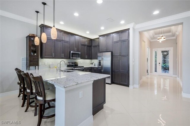 4318 Aurora St, Naples, FL 34119 - kitchen featuring appliances with stainless steel finishes, a peninsula, ornamental molding, light stone counters, and tasteful backsplash