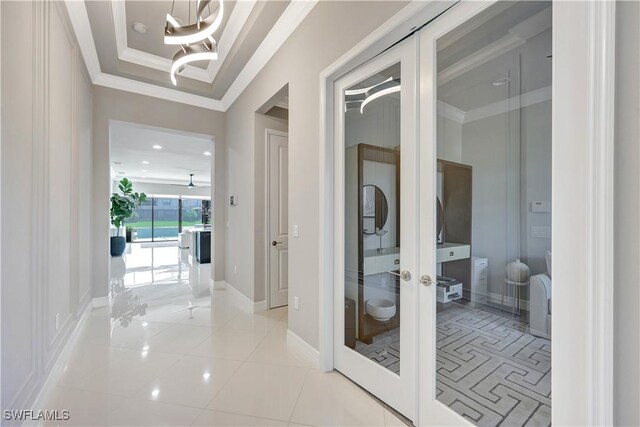 4318 Aurora St, Naples, FL 34119 - corridor with french doors, a chandelier, ornamental molding, light tile patterned floors, and recessed lighting