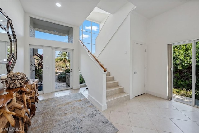 entrance foyer with a high ceiling, light tile patterned floors, and plenty of natural light