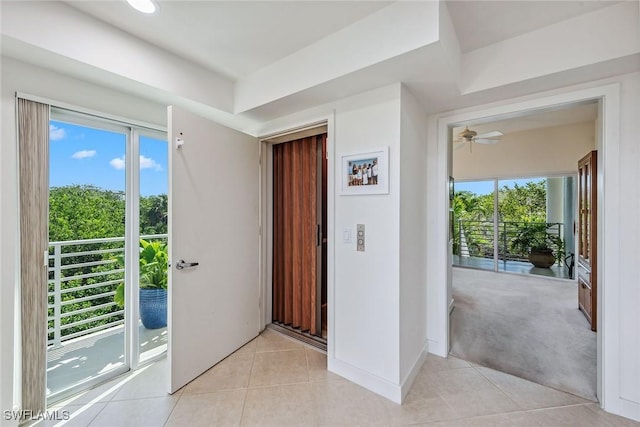 interior space featuring baseboards, light tile patterned floors, and plenty of natural light