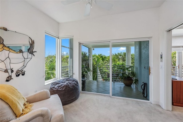 living area with ceiling fan and light colored carpet