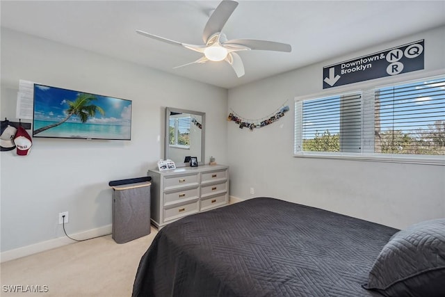 carpeted bedroom featuring baseboards and a ceiling fan