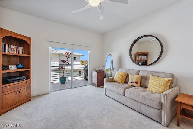 living area featuring light carpet and ceiling fan