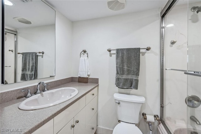 bathroom featuring shower / bath combination with glass door, toilet, and vanity