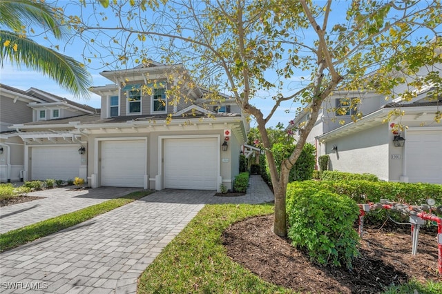 6953 Avalon Cir Unit 1804, Naples, FL 34112 - view of front of house featuring decorative driveway, a garage, and stucco siding