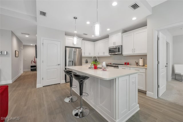 6953 Avalon Cir Unit 1804, Naples, FL 34112 - kitchen with appliances with stainless steel finishes, light wood-type flooring, white cabinetry, light countertops, and recessed lighting