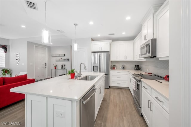 6953 Avalon Cir Unit 1804, Naples, FL 34112 - kitchen with stainless steel appliances, a sink, light wood-type flooring, backsplash, and white cabinets