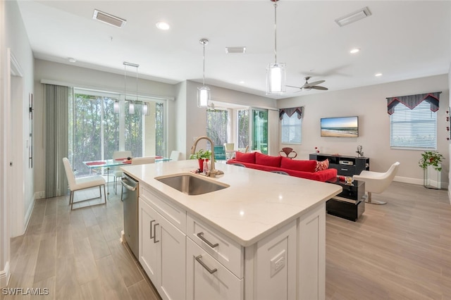 6953 Avalon Cir Unit 1804, Naples, FL 34112 - kitchen with a sink, baseboards, light wood-type flooring, white cabinetry, and an island with sink
